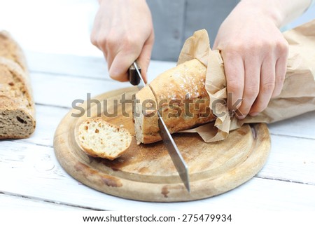 Bread. Woman hands cutting bread on the kitchen counter