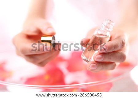 Nail conditioner, make sure to look your hands. Woman paints the nails cuticle oil and nail