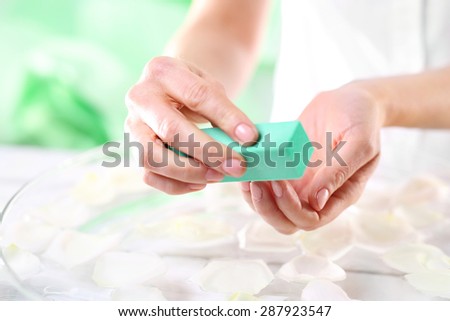 Woman polishing nails.\
Manicure, natural nail manicure studio
