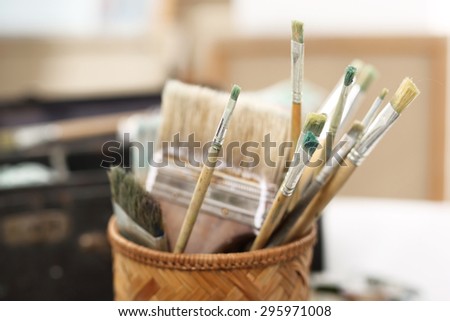 Art classes, painting workshop. The composition of paint brushes on the background of art studio