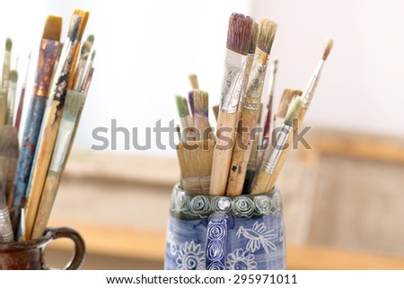In the art studio. The composition of paint brushes on the background of art studio
