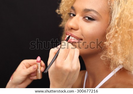 Makeup mouth. Make-up artist paints lips of a beautiful woman