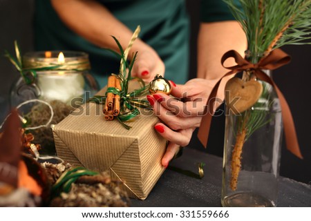 Packaging holiday gifts.Woman packs a Christmas gift and decorating the house with Christmas decorations
