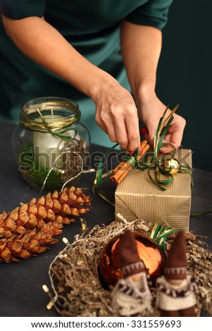 Art gift wrapping. Christmas. Woman packs a Christmas gift and decorating the house with Christmas decorations