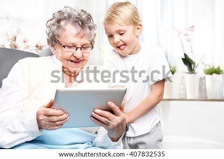 Grandmother and grandson. Grandmother with grandson playing on the tablet.