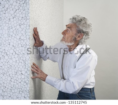 old man with a white shirt is put your hands on the white wall