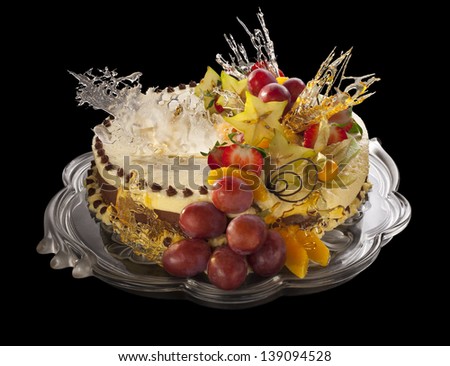 mousse cake decorated with fruits isolated on a black background