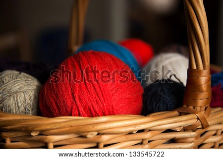 balls of wool of different colors in a wicker basket