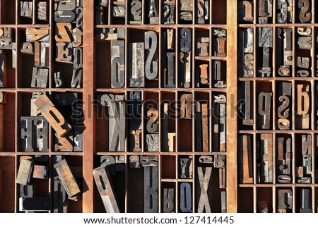 A box of old vintage printing press letter blocks in a old wooden box