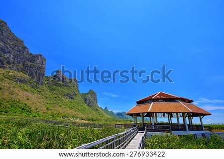 wooden bridge to pavilion with mountain and blue sky