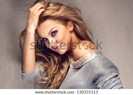 Portrait of wonderful young blonde woman with long hair looking at camera, smiling.