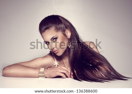 Photo Of Beautiful Brunette Woman With Long Hair Wearing A Lot Of Jewelry.