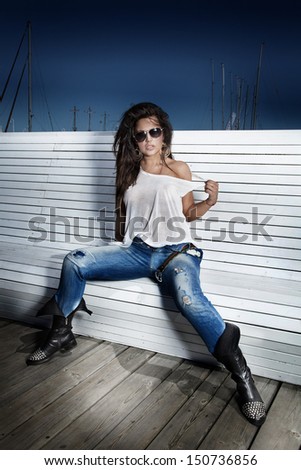 Fashion photo of attractive brunette woman with sunglasses posing.