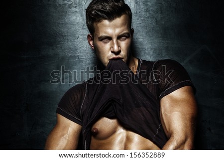 Portrait of young handsome man posing, showing perfect body.