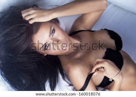 Sexy woman with black hair posing, looking at camera.