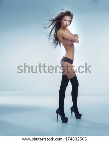 Sexy Brunette Woman Posing Naked In Studio, Looking At Camera. Beautiful Lady With Perfect Fitness Body