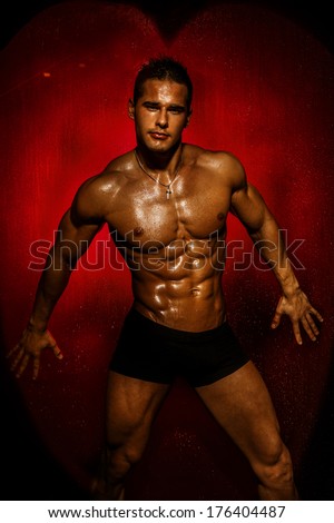 Muscular young sexy wet naked handsome man posing. Valentine\'s day.