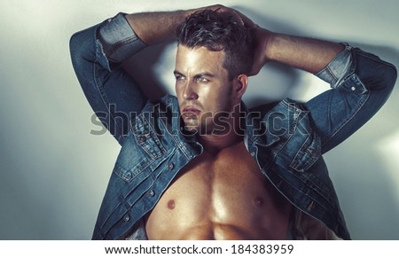Portrait of sexy handsome man posing in jeans clothes, looking away.