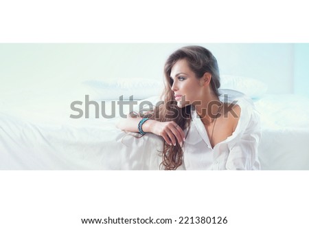 Beautiful young woman relaxing in bedroom. Indoor shot.
