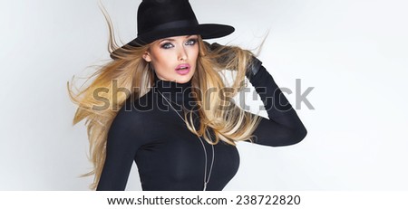 Elegant beautiful blonde woman posing in hat. Studio photo. Girl with long hair.