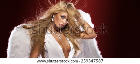 Beauty portrait of sensual blonde woman with long healthy hair.Girl posing with angel wings