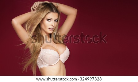 Blonde sexy woman with perfect slim body posing in sensual lingerie. Girl with long hair.