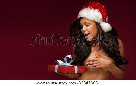 Portrait of brunette sexy woman with red Santa Claus hat. Christmas content.