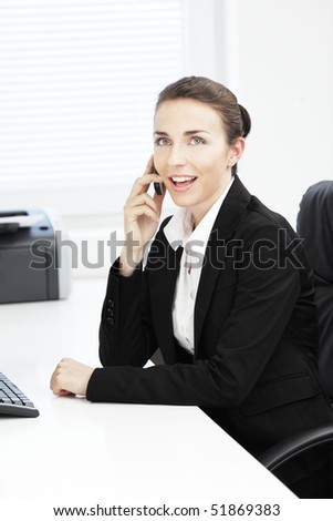 Beautiful young businesswoman talking on cell phone at office