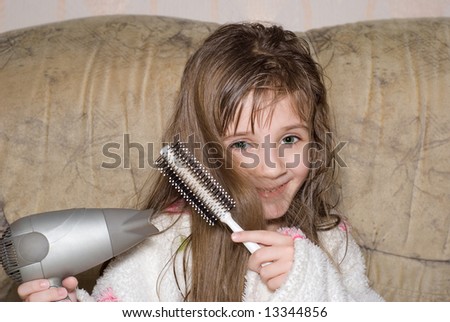 The little girl dries hair after bathing