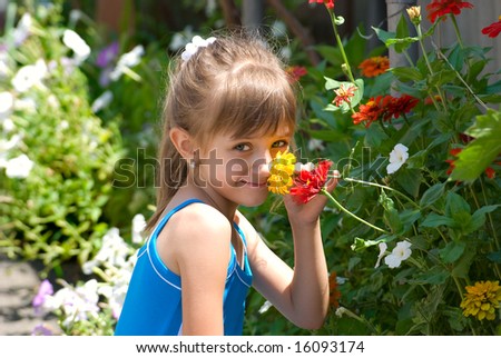 The girl smells flowers on a flower-bed