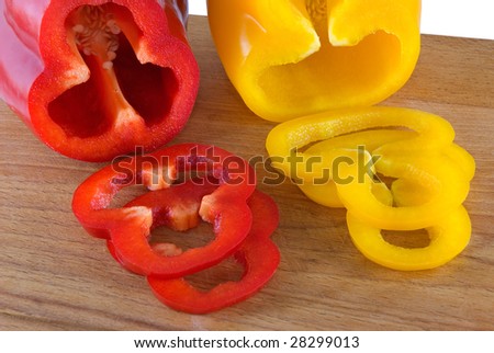 Red and yellow sweet pepper lays on a chopping board