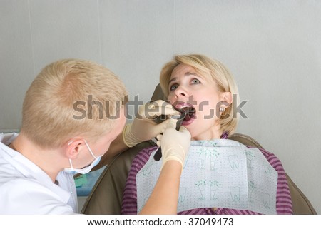 The dentist extracts out a sick tooth to the young woman