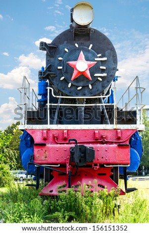 The ancient steam locomotive stands on a pedestal