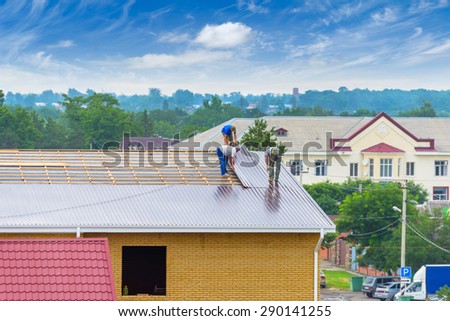 Workers perform roofing works