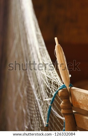 fishing net weaving shuttle and a chair is used for