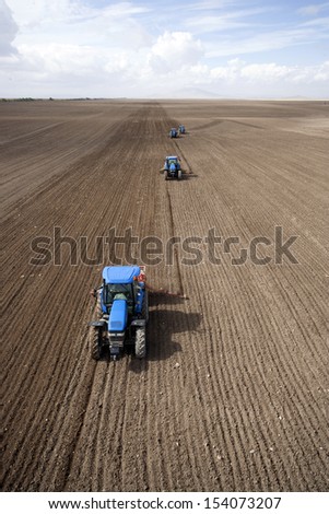 Image of three Tractors planting farm fields
