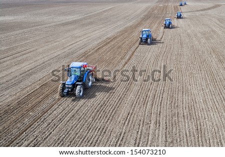 Image of five Tractors planting farm fields