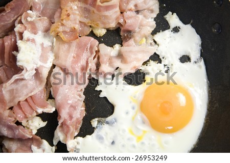 egg and bacon frying in a pan