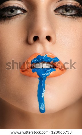 Beautiful closeup portrait of young caucasian female, orange lips, Dripping Dark blue makeup, perfect skin.