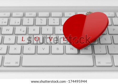 Heart over white keyboard with the word love. Love concept