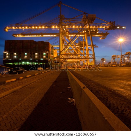 Moored container ship and gantry cranes at night