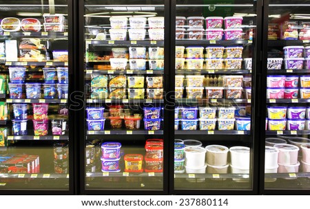TORONTO, CANADA - OCTOBER 31, 2014: Different brands and flavors of ice cream on fridge shelves in a supermarket. Based on studies, half of the population in North America eat ice cream regularly.