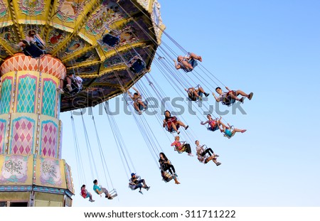 TORONTO, CANADA - AUGUST 25, 2014: Swing ride at Canadian National Exhibition in Toronto, Ontario, Canada. CNE is largest annual fair in Canada and the seventh largest in North America.
