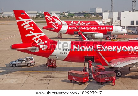 BANGKOK, THAILAND - MARCH 3, 2014: unloading of baggage from the  Air Asia aircraft in Bangkok airport on March 3, 2014. Air Asia company is the largest low cost airlines in Asia. Canon 5D Mk II.