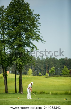 Man playing golf on beautiful sunny green golf course
