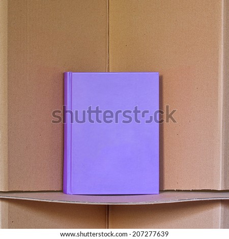 New purple book standing on the triangular cardboard shelf