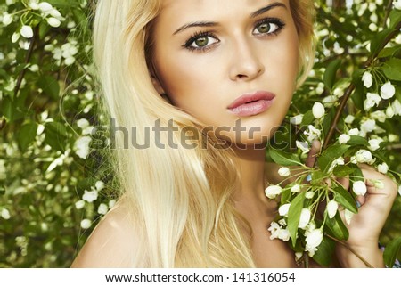 portrait of beautiful blond woman with apple tree. summer