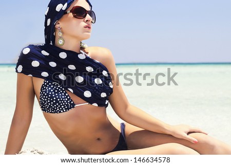 beautiful woman in blue shawl on beach.your text here