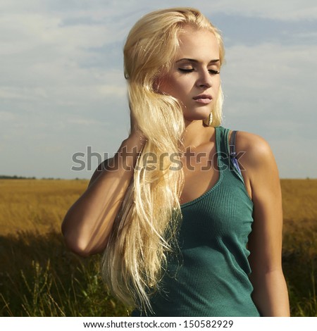 fashionable Beautiful blond girl on the field.beauty beauty woman. nature background.ears of wheat