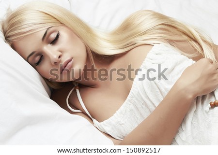 sleeping beautiful blond girl. beauty woman. white bed. hair care. sweet dreams. white dress. headlights